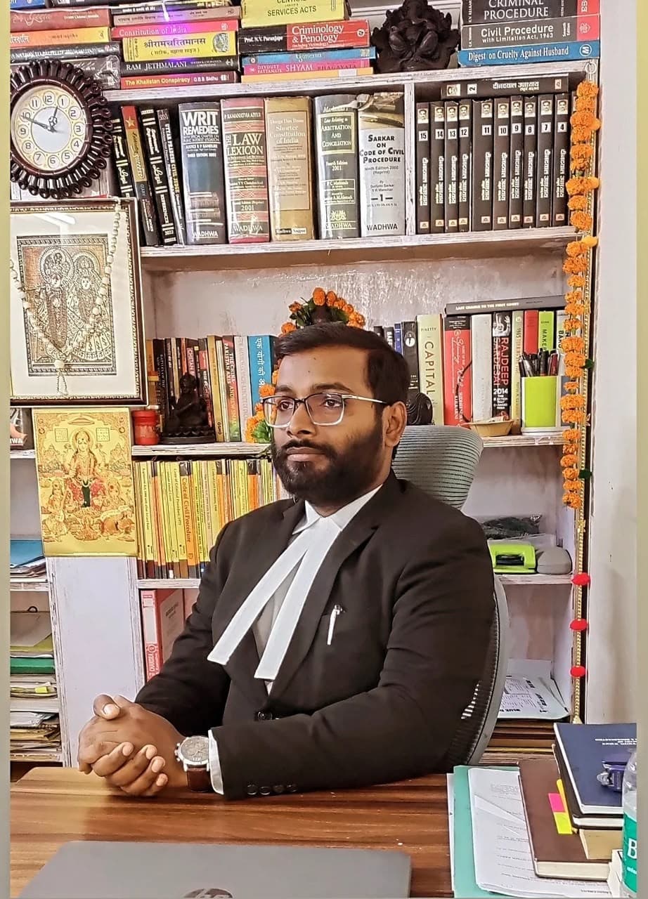 Advocate Shubham Singh in court dress seated before chamber law library