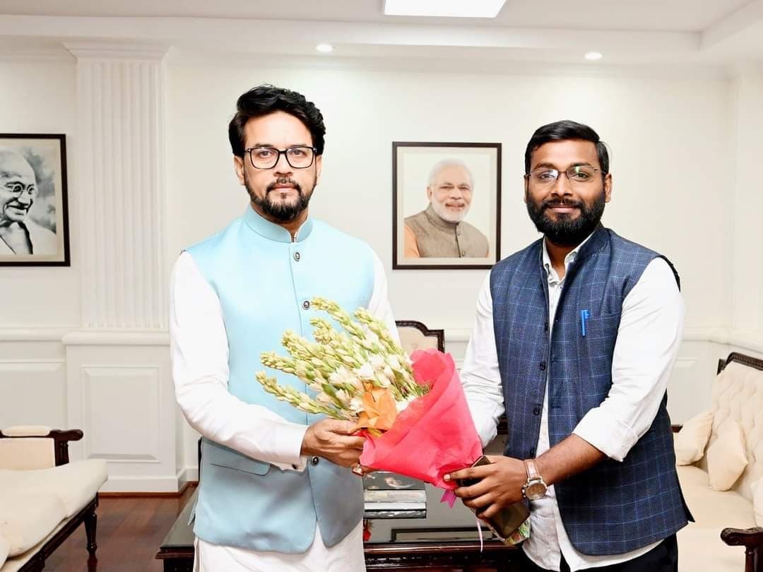 Advocate Shubham Singh presenting a floral bouquet to Union Minister Anurag Thakur