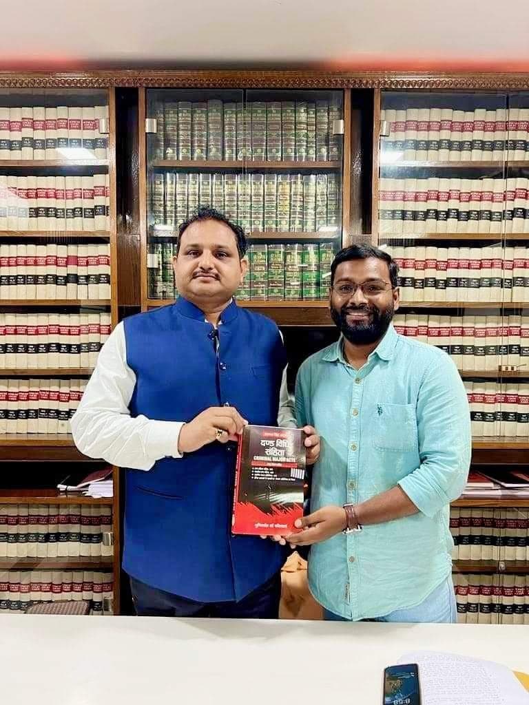 Advocate Shubham Singh and co-counsel presenting Code of Criminal Procedure treatise in law library